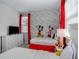 Whimsical bedroom with themed decor, featuring two beds, a TV, and cheerful red accents at 1810 Caribbean View Ter, Kissimmee, FL 34747