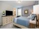 Well-lit bedroom features a large TV with media console, a stylish mirror, and an ensuite bathroom at 1810 Caribbean View Ter, Kissimmee, FL 34747