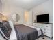 Bright bedroom features a large TV with media console and a decorative mirror at 1810 Caribbean View Ter, Kissimmee, FL 34747