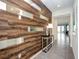 Modern foyer with unique wood-paneled wall featuring decorative mirrors, plus a console table with lamp at 1810 Caribbean View Ter, Kissimmee, FL 34747