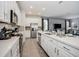 Open-concept kitchen boasts sleek white cabinets, stainless steel appliances, and a functional design at 1810 Caribbean View Ter, Kissimmee, FL 34747