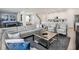 Spacious living room featuring a modern sofa, coffee table, and access to the kitchen and dining areas at 1810 Caribbean View Ter, Kissimmee, FL 34747