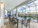 Spacious outdoor patio featuring a dining area, with a screened pool and lush backyard view at 1810 Caribbean View Ter, Kissimmee, FL 34747