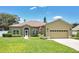 Charming single-story home featuring manicured lawn, arched windows, and an attached two-car garage at 1822 Ashton E Dr, St Cloud, FL 34771