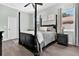 Comfortable bedroom features a four-poster bed, hardwood floors, and large windows creating a cozy and serene space at 1822 Ashton E Dr, St Cloud, FL 34771
