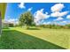 A spacious backyard showcases a large lawn and mature trees, providing a serene and private outdoor retreat at 1856 Castleton Dr, St Cloud, FL 34771