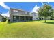 Large, lush backyard view shows a covered patio, perfect for outdoor entertaining at 1856 Castleton Dr, St Cloud, FL 34771