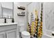 Stylish bathroom featuring gray vanity, marbled shower and tile, complemented by modern fixtures and thoughtful decor at 1856 Castleton Dr, St Cloud, FL 34771