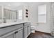 Bright bathroom featuring a modern vanity with gray cabinets, and a toilet next to a window for natural light at 1856 Castleton Dr, St Cloud, FL 34771