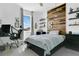 A modern bedroom featuring a statement wall of reclaimed wood, minimalist decor, and an adaptable workspace by the window at 1856 Castleton Dr, St Cloud, FL 34771
