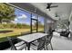 Inviting screened patio with ceiling fans and an outdoor dining area offers a relaxing space with views of the lush backyard at 1856 Castleton Dr, St Cloud, FL 34771