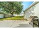 Exterior shot of backyard with a large tree, grill, and partial privacy fence at 1913 Manatee Ct, Kissimmee, FL 34759