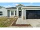 Inviting front entrance with tiled walkway, decorative stone accents, and black front door at 1913 Manatee Ct, Kissimmee, FL 34759
