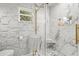 Elegant bathroom with white marble-styled tile walls and geometric tile floors at 1913 Manatee Ct, Kissimmee, FL 34759