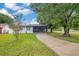 Beautiful single story home showcasing a lush green lawn, mature trees and screened in porch at 2 S Lavon Ave, Kissimmee, FL 34741