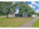 Charming home exterior with large trees, sidewalk, and manicured lawn at 2 S Lavon Ave, Kissimmee, FL 34741