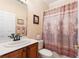 Bright bathroom featuring a vanity with a white sink, a large mirror, and a decorative shower curtain at 214 Verona Dr, Kissimmee, FL 34759