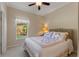 Comfortable bedroom featuring a cozy bed, a window overlooking the yard, and a ceiling fan at 214 Verona Dr, Kissimmee, FL 34759