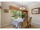 Cozy dining room features a decorative chandelier, classic china cabinet, and a window view of the outdoors at 214 Verona Dr, Kissimmee, FL 34759