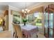 Light-filled dining area features an elegant chandelier and views of the lush backyard through a large window at 214 Verona Dr, Kissimmee, FL 34759