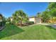 Green front lawn featuring a large palm tree and a paver driveway leading to the garage at 214 Verona Dr, Kissimmee, FL 34759
