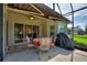 Screened-in lanai with a dining table and chairs, offering a relaxing outdoor space with a view of the backyard at 214 Verona Dr, Kissimmee, FL 34759