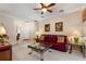 A spacious living area featuring plush carpeting, a ceiling fan, and a comfortable red couch at 214 Verona Dr, Kissimmee, FL 34759