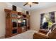 Cozy living room features a large entertainment center with television and comfortable seating, illuminated by natural light at 214 Verona Dr, Kissimmee, FL 34759