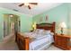 Bright main bedroom showcasing a decorative wooden bed frame, ceiling fan, and neutral walls at 214 Verona Dr, Kissimmee, FL 34759