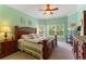 Spacious main bedroom with wooden furniture, a ceiling fan, a large window, and neutral-colored carpet at 214 Verona Dr, Kissimmee, FL 34759