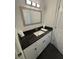 Stylish bathroom featuring a black granite countertop, white cabinets, and modern fixtures for a clean look at 2356 Chadwick Cir, Kissimmee, FL 34746