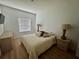Cozy bedroom featuring a queen-size bed with decorative pillows, two bedside lamps, and wood flooring at 2356 Chadwick Cir, Kissimmee, FL 34746