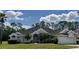 Well-maintained single-Gathering home featuring a manicured lawn, mature trees, and a two-car garage at 2356 Chadwick Cir, Kissimmee, FL 34746
