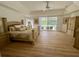 Spacious main bedroom with tray ceiling, fan, wood floors, and sliding glass doors to screened-in pool at 2356 Chadwick Cir, Kissimmee, FL 34746