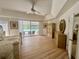 Main bedroom with wood floors, tray ceiling, fan, and sliding doors to screened-in pool and backyard at 2356 Chadwick Cir, Kissimmee, FL 34746