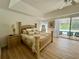 Bright main bedroom with king-sized bed, wood floors, and sliding doors leading to a screened-in pool at 2356 Chadwick Cir, Kissimmee, FL 34746