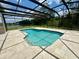 A sparkling screened-in pool surrounded by a spacious patio and tranquil landscaping provides a serene backyard escape at 2356 Chadwick Cir, Kissimmee, FL 34746