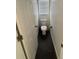 Small powder room with toilet, neutral paint, dark floors, and small window at 2356 Chadwick Cir, Kissimmee, FL 34746