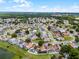 This aerial shot showcases a beautiful residential neighborhood with mature trees, a pond, and easy access to nearby amenities at 2561 Montego Bay Blvd, Kissimmee, FL 34746