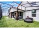 This backyard has artificial turf, a built-in outdoor kitchen, and covered seating space at 2561 Montego Bay Blvd, Kissimmee, FL 34746