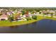 Aerial shot showcases homes near a tranquil lake with green lawns, trees, and a white picket fence at 2703 Eagle Canyon S Dr, Kissimmee, FL 34746