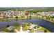Expansive aerial perspective of homes surrounding a serene lake, nestled among lush trees and well-maintained lawns at 2703 Eagle Canyon S Dr, Kissimmee, FL 34746
