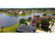 Overhead view of lakeside homes featuring manicured lawns, palm trees, and a peaceful lake setting at 2703 Eagle Canyon S Dr, Kissimmee, FL 34746