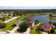 Aerial view of a charming home with a well-kept lawn, surrounded by a tranquil lake and lush greenery at 2703 Eagle Canyon S Dr, Kissimmee, FL 34746