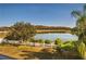 Beautiful view of the lake from the property, surrounded by lush trees and greenery and a picket fence at 2703 Eagle Canyon S Dr, Kissimmee, FL 34746