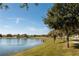 Scenic pond view with a paved walking path and lush green grass, providing a tranquil outdoor experience at 2703 Eagle Canyon S Dr, Kissimmee, FL 34746