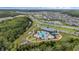 Aerial view of community pool with playground, clubhouse, and surrounding neighborhood at 2838 Common Crane Ct, Harmony, FL 34773