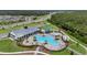 Community pool, playground, and splash pad with outdoor seating and palm trees visible from above at 2838 Common Crane Ct, Harmony, FL 34773