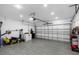 Spacious two-car garage featuring tile flooring and ample storage for tools and equipment at 2838 Common Crane Ct, Harmony, FL 34773