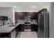 Spacious kitchen featuring granite countertops, dark wood cabinets, stainless steel appliances, and tile flooring at 2838 Common Crane Ct, Harmony, FL 34773